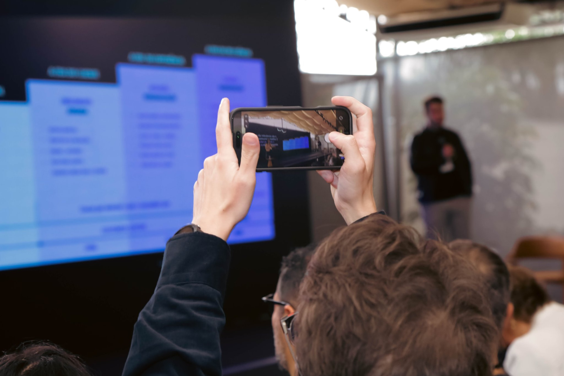 Participante fotografando a apresentação no palco